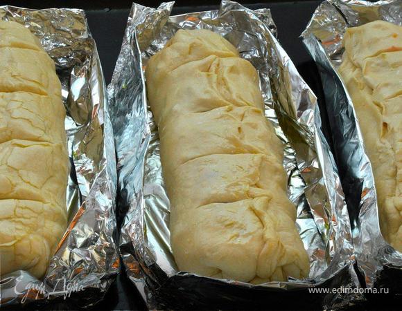 Раскатать слоеное тесто, равномерно выложить начинку и распределить по поверхности. Скатать тесто в рулет и закрыть края. Сверху сделать надрезы острым ножом 3-4 раза и смазать верх оливковым маслом. Из фольги смастерить формочки, чуть большего размера, чем ваши штрудели. Смазать оливковым маслом, положить в формы штрудели и разместить формочки на противне.