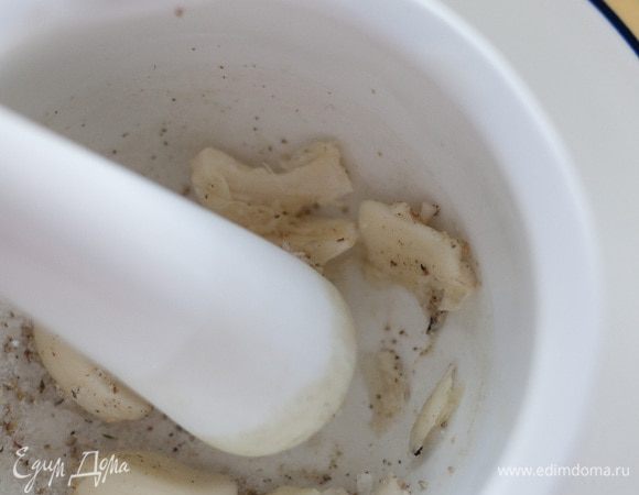 Чеснок почистить и растереть с солью и перцем.