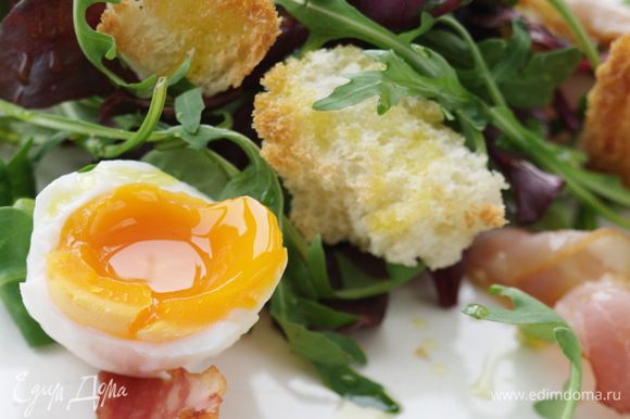 Выложить на тарелку слоями листья салата, хлеб с беконом, яйца, присыпать сыром.
