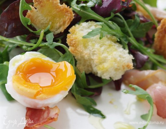 Выложить на тарелку слоями листья салата, хлеб с беконом, яйца, присыпать сыром.