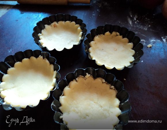 Разогрейте духовку до 200*. Раскатайте тесто в тонкий пласт и вырежьте из них круги и положите в смазанные сливочным маслом формы. На тесто положите начинку. 
