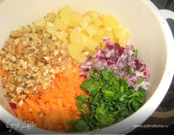 Ананас нарезать мелкими кубиками,морковь вымыть,очистить,натереть на крупной тёрке.Грецкие орехи порубить.Очистить и меленько нарезать лук.Вымыть и обсушить петрушку,отложить несколько веточек для украшения,остальное мелко порубить.