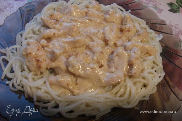 Выкладываем готовые спагетти на тарелку, сверху выкладываем нашу курицу под сырным соусом и посыпаем измельчёными в блендере грецкими орехами. Приятного аппитита.