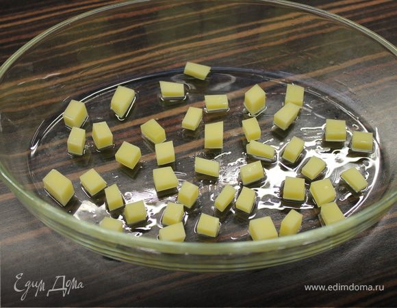 Форму для запекания смазать маслом и выложить на дно кубики сыра.