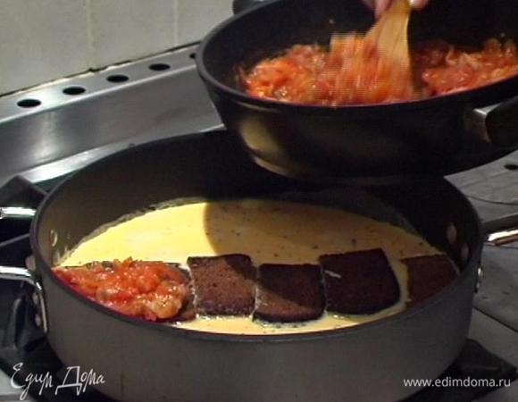 Оставшееся растительное масло разогреть вместе со сливочным маслом в глубокой сковороде, вылить в нее взбитые яйца. В центр выложить гренки, полить соусом из помидоров и присыпать тертым сыром.