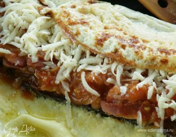 Как только яйца схватятся снизу, сделать рулет, завернув края омлета на хлеб, и накрыть крышкой на 2 минуты.