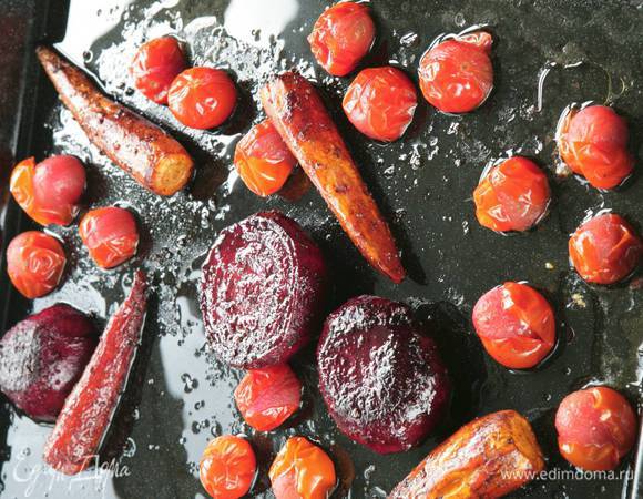 Через 20 минут перевернуть овощи и добавить к ним помидоры; запекать еще минут 15–20 до готовности.