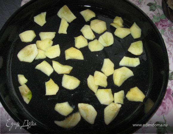 Берём протвень и смазываем его растительным маслом. Наши яблоки мы очищаем от кожуры, режим небольшими ломтиками и выкладываем на провень, роспределяя равномерно.