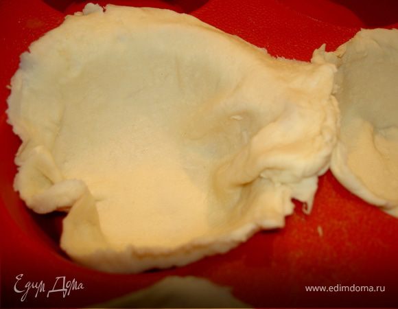 Раскатываем тонким слоем тесто и вырезаем круги диаметром немного больше углублений в форме для выпечки булочек. Еще немного растянем их руками и укладываем в форму, смазанную маслом и присыпанную мукой.