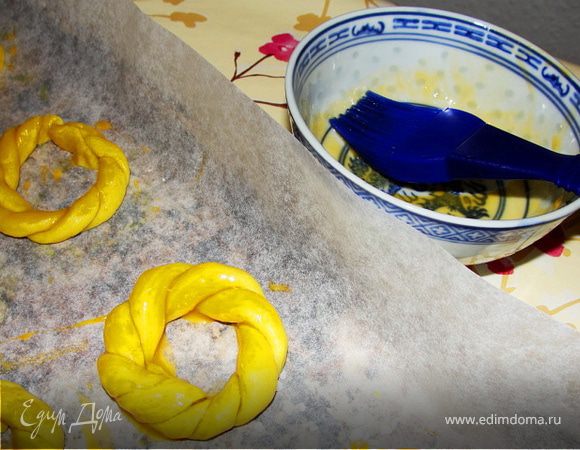 Выкладываем наши готовые печенья на застеленный бумагой для выпечки противень и смазываем желтком.