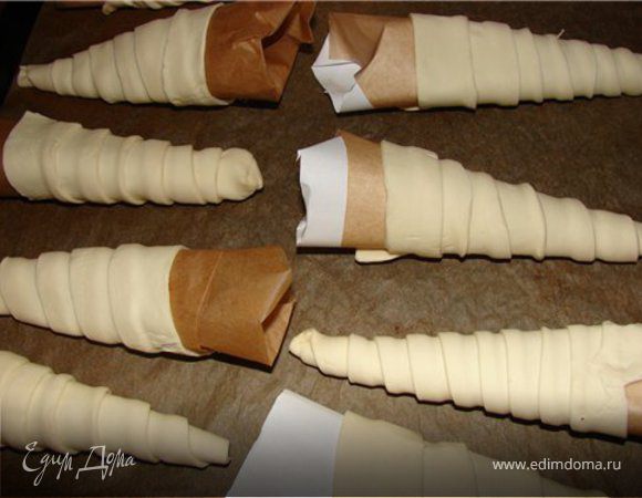 Лист А4 разделить пополам, свернуть кулечки, низ подрезать, обернуть фольгой.Пласт слоенного теста разрезать на 6 полосок
Каждую раскатать, чтобы увеличилась в длину раза в 2
Конус обматывать тестом с кончика по спирали, в конце защипнуть края. Выпекать в разогретой духовке при 180 °С примерно 10 минут.
Снимаются очень легко(так что можно формочки использовать еще раз)
