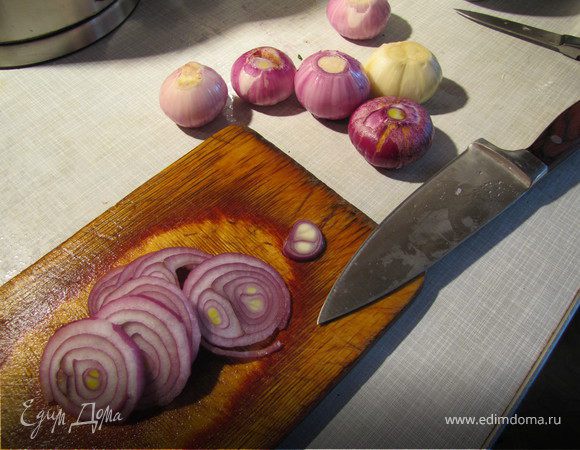 Очистить и нарезать лук кольцами.
Лучше брать светлый лук - в первый раз у меня было 2 крупных луковицы. В этот раз в наличии был мелкий красный лук, 8 шт. - получилось по одной на порцию - но он приобретает при запекании некрасивый темный оттенок, так что я советую вам использовать обычный светлый репчатый лук, ну или жемчужный (обычно на порядок дороже). Думаю, здорово будет и лук-порей. На Ваш выбор)