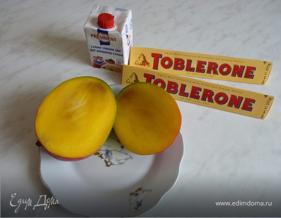 Шоколад растопить на водяной бане, охладить.
Сливки взбить. Добавить растопленный шоколад, взбить. Взбить можно слегка, чтобы получился мраморный рисунок. Манго нарезать кусочками. Стручок чили прорезать в длину и удалить зёрнышки, а сам стручок мелко порубить. 
Разложить мусс по креманкам. Чили вместе с кусочками манго выложить сверху.
Используя нож для чистки овощей, снять с шоколада немного стружки - для украшения.