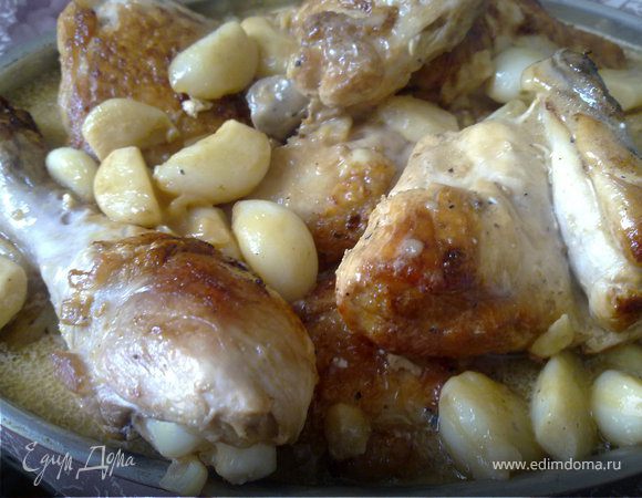 На дно кастрюли (с соусом) выложить куски курицы и поставить без крышки в духовку на 20 минут, периодически поливая курицу соусом. Перед подачей курицу выложить на блюдо. Муку смешать со сливками, добавить к соусу, добавить еще 1 ст.л. коньяка, дать закипеть, проварить еще 5 минут, и подать к курице полив ее сверху. Чеснок получился очень ароматным, сладким. Очень вкусно в этот соус макать хлеб.