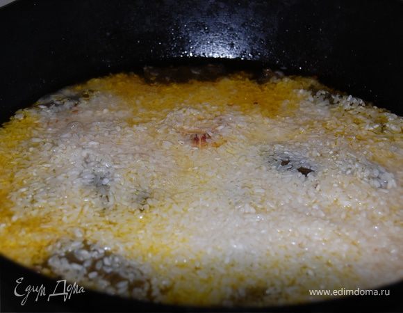 Рис хорошо промыть под проточной холодной водой.(Если у вас рис,который долго варится замочите его предварительно в воде с щепоткой соли),откинуть на сито и дать воде стечь.
Выложить в казан ровным слоем,увеличить огонь до максимума и влейте кипяток через шумовку,так чтобы он покрыл рис на 1-2см( в зависимости от вашего риса).Не накрывайте.
