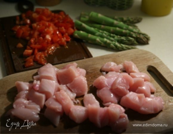 Промыть спаржу  под холодной водой и обрезать жесткие кончики.Помидоры нарезать мелкими кубиками.Куриные грудки - крупными кубиками.
