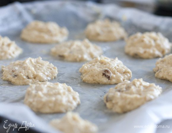 Застелить противень бумагой для выпечки, смазать ее сливочным маслом. Выложить на бумагу столовой ложкой шарики из теста и слегка прижать их сверху (расстояние между ними должно быть не меньше 3 см).