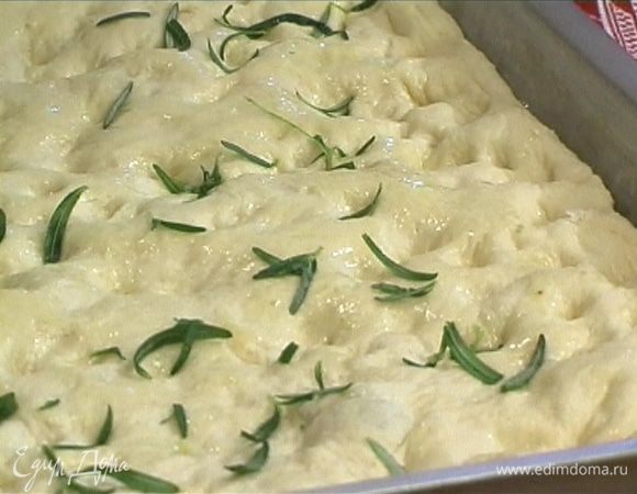 Сделать пальцами в тесте небольшие вмятины, смазать фокаччу оливковым маслом и поставить в разогретую духовку. Выпекать, пока она не станет золотисто-коричневого цвета.