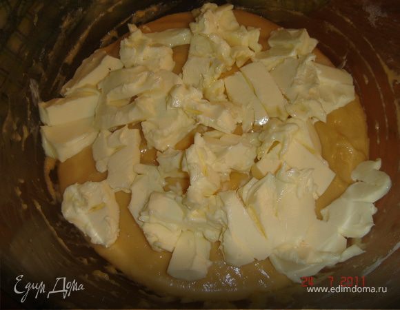 Поверх теста выложить кусочки масла,накрыть полотенцем и убрать в теплое место на 1 час.Изюм замочить в роме.