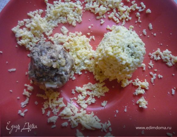 Из фарша формируем шарик размером с желток, обсыпаем его тертым желтком. Из перца вырезаем клюв и гребешок, из маслин вырезаем глазки.