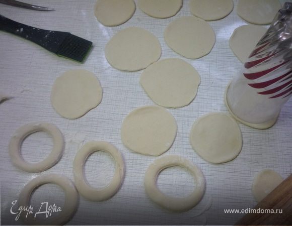 Раскатываем маленький круг до диаметра большого круга, если получилось не очень ровно, то подравниваем края стаканом, которым вырезали большой круг и смазываем его поверхность небольшим количеством воды.