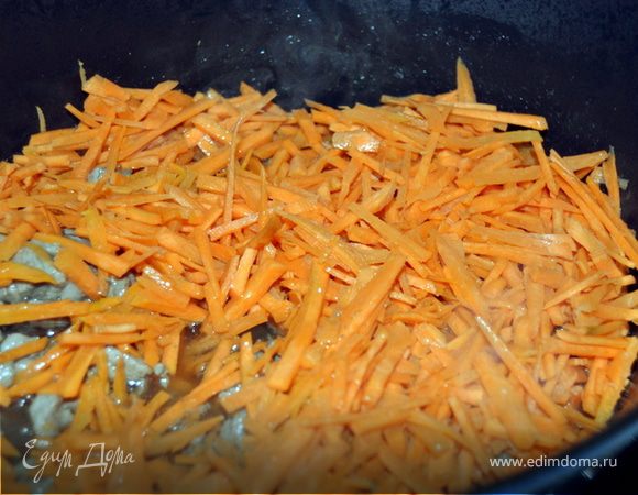 Как только мясо подрумянилось, добавляем морковь.Обжариваем.