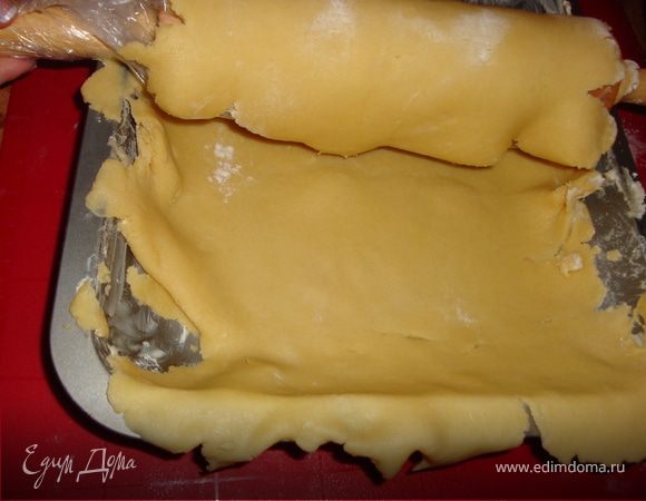 Намотать тесто на скалку и аккуратно развернуть над смазанным маслом противнем...