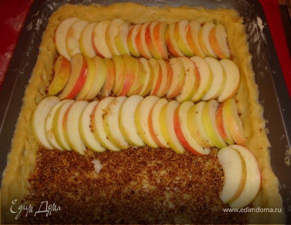 На получившееся из теста основание пирога высыпать пряно-ореховую смесь и разровнять по всей поверхности. Сверху красиво уложить яблочные дольки...