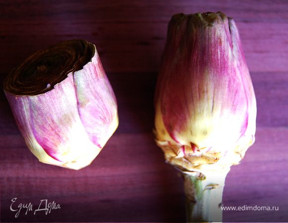 Артишоки промыть, стебель отрезать. Очистить от жестких наружных лепестков. С плодоножки срезать верхний слой, как на фотографии. С бутона срезать кончики лепестков, так как они тоже жесткие и на них есть колючки. 