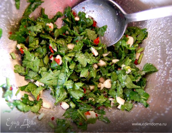 Тем временем готовим смесь пряностей. Чеснок мелко режем, смешиваем с рубленой петрушкой, добавляем чайную ложку с горкой морской мелкой соли, красный перец (количество по желанию), черный перец. 