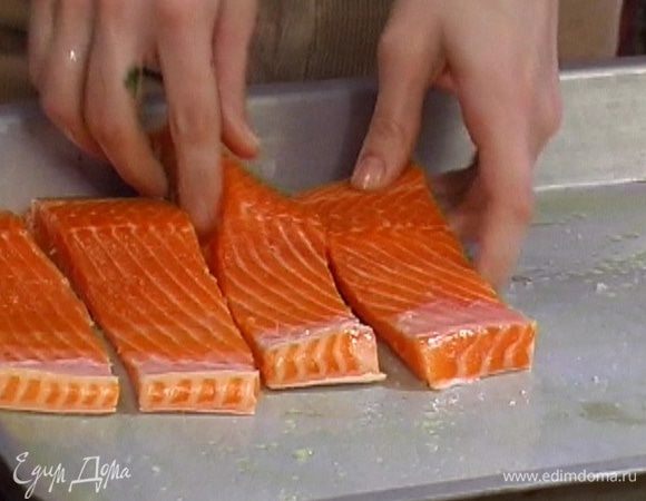 Смазать противень оливковым маслом и уложить рядами куски форели и овощи. 