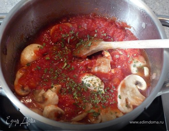 Тем временем на масле обжарить порезанные шампиньоны и оставшуюся половину лука. Добавить томаты в собственном соку и вскипятить. Соус приправить солью, перцем, сахаром и базиликом.