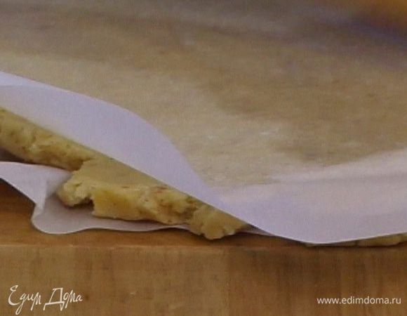 Поместить охлажденное тесто между двумя листами бумаги для выпечки и раскатать.