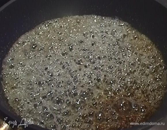 В большую сковороду всыпать оставшийся сахар, смочить его водой, поставить на огонь и сварить карамель.