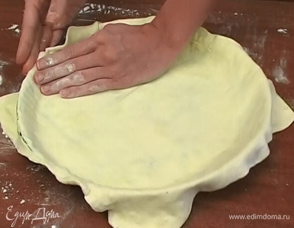 Слоеное тесто раскатать, уложить в форму, так чтобы свисали края, и смазать оливковым маслом.