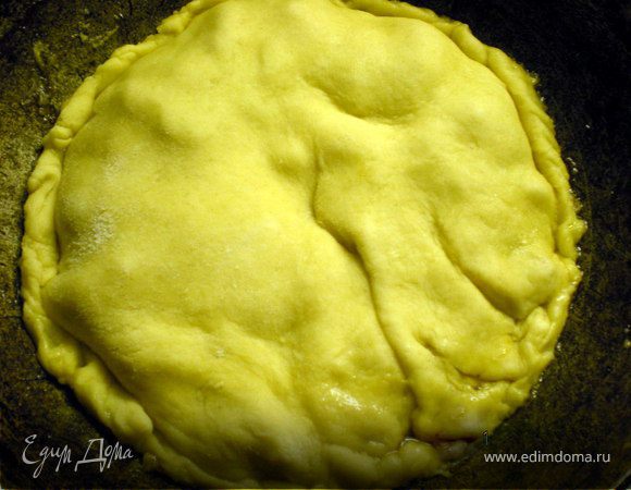 Если сока много образовалось,то его нужно слить(вычерпать ложкой)Не выливать! Им можно будет полить уже готовый пирог.
Вытаскиваем тесто из холодильника,быстро раскатываем в круглый блин ( примерно 3мм толшщиной) и закрываем им яблоки сделав несколько проколов.