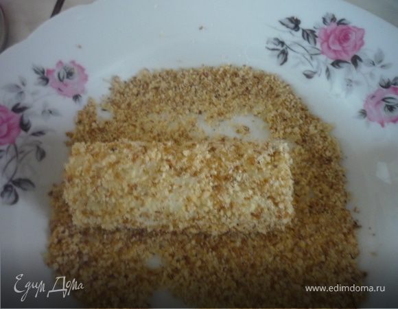 Краешки рулетиков срезаем, разрезаем пополам наши рулетики. Орехи мелко точем и просеиваем через дуршлаг с крупной сеткой. Теперь рулеты надо обвалять в орехах: с креветками - в миндале, с рыбой - в фундуке, ну или кому как нравится.