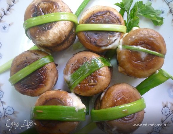 Обе половинки шляпок, пока они теплые,  соединяем и связываем веточкой зелени, кладем узлом вниз и оставляем остыть минут на 40. Лишние длинные края зелени обрезаем. Чем больше уместится креветок в шляпки, тем вкуснее.