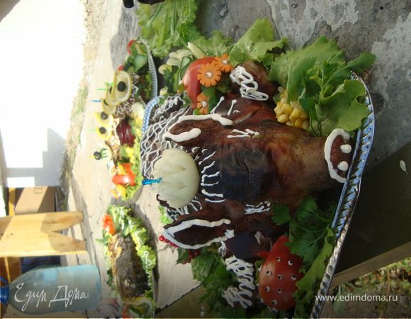 Затем ушки ,хвостик и ножки поросенка обернуть фольгой ,самого поросенка тоже неплотно накрыть фольгой и выложить его в глубокий противень,поставить в разогретую до 180 градусов духовку на 2 часа.Через 2 часа снять фольгу и оставит еще на час.ПРоверить готовность деревянной палочкой,чтоб не выделялся сок.Вынуть из духовки, снять нитку или зубочистки ,выложить на красивый разнос и украсить на свое усмотрение зеленью фруктами и овощами.