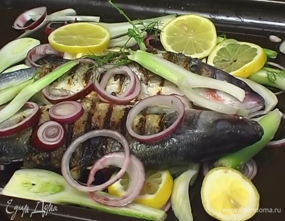 На дно противня уложить половину нарезанного лука, фенхеля и лимона, сверху разложить обжаренную рыбу, полить оливковым маслом и белым вином, а затем выложить оставшийся лук, фенхель и лимоны. Запекать 20 минут в разогретой духовке.