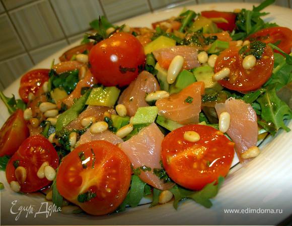 Добавьте семгу порезанную ломтиками и посыпьте слегка обжаренными кедровыми орешками. Полейте заправкой.
