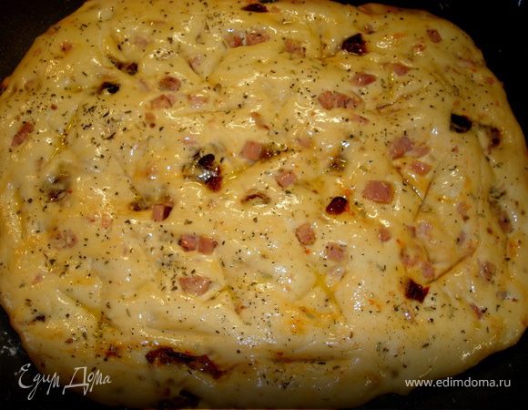 Сначала ветчина и помидоры будут сопротивляться… Да куда им, итальянским неженкам, против наших славянских ручек))) Потихоньку - помаленьку и все, хорошо все размешали… Теперь выложили нашу фокаччу на противень, предварительно смазанный растительным маслом маслом, растянули ее в разные стороны до нужной вам толщины и длины, накрыли полотенцем и дали подойти 40 минут. Затем взяли палочку (у меня от суши) или просто руками, и сделали в тесте выемки для того, чтобы когда мы намажем его оливковым масло, оно не стекло вниз, а задержалось в этих ямках. Кстати, об оливковом масле… У меня для таких случаев, отдельно в баночке, в холодильнике, хранится оливковое масло, в которое я через пресс пропустила чесночок, в пропорциях 100мл масла на 5-6 больших зубчиков чеснока. И вот этим самым маслом (оставшиеся 1,5 столовые ложки) мы смазываем нашу повторно подошедшую фокаччу, посыпаем сверху смесью прованских трав… Если вы не хотите, чтобы наш хлеб пах чесноком, то смажьте просто оливковым маслом. Почему я не ложу чеснок сверху фокаччи просто так, в натуральном виде? Потому что как-бы я не пыталась, но он у меня банально пригорает при выпечке. А так убили двух зайцев: запах и вкус чеснока присутствует, а горелых корочек сверху фокаччи нет...