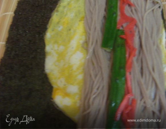 На собу укладываем порезанный вдоль огурец и красный маринованный дайкон. вместо дайкона можно использовать другие овощи красного цвета.