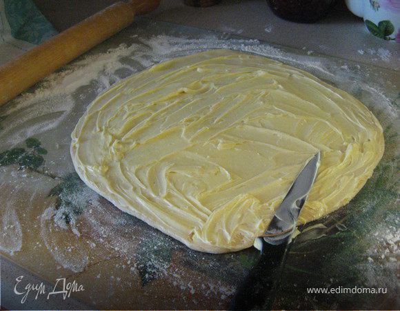 Внимание! Берем 1 шар теста, раскатываем из него прямоугольник до толщины в 1 см, берем 1 шарик из масла и муки(шаг 4) и равномерно им намазываем всю полученную поверхность.
 Причем, если это шар побольше, то и шарик побольше! Это здесь важно! 
Складываем противоположные края нашего прямоугольника к середине  внахлест (получается размер 1/3 пласта), потом с другой тоже внахлест, в итоге получается небольшой прямоугольник, равный по размеру 1/9 пласта. Выкладываем на полотенце, подсыпанное мукой и убираем примерно на 1 час в холодильник. Так поступаем с каждым шаром теста(шаг 3) и шариком (шаг 4). У нас получается в холодильнике 4 "конверта". 