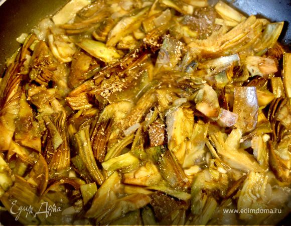 Артишоки добавить к луку, перемешать. Влить один половник горячего бульона, немного посолить. Тушить под крышкой 20 минут на медленном огне. В конце посыпать майораном, выключить и держать под крышкой.