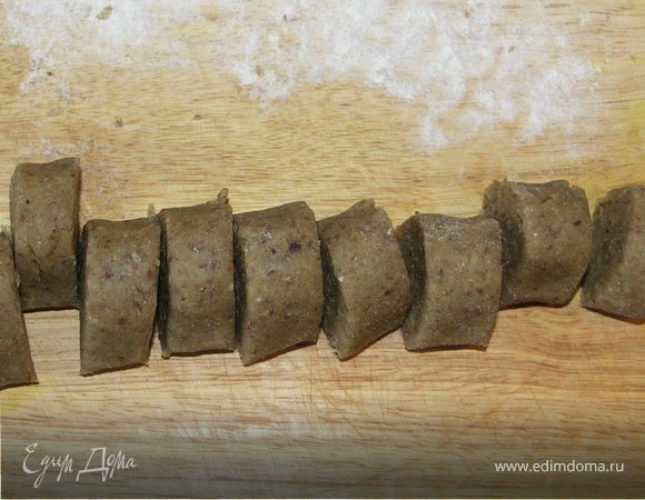 На разделочную доску насыпать чуть ржаной муки и немного вымесить тесто.Разделить на пять частей(у меня вышло 5 противеней печенья)Каждую часть(по очереди)раскатываем в толстый жгутик и режем на кусочки.