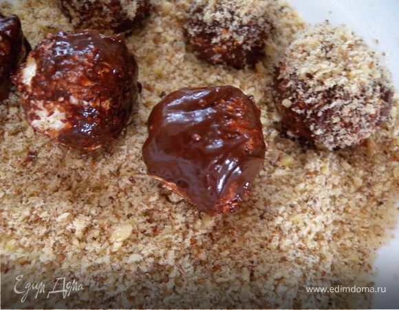 чтобы шарики не прилипали к тарелке я сначала густо посыпала ее измельченным миндалем... Потом выложила все шарики и опять потрусила миндальными крошками. Отправила в холодильник на 30 минут. Потом повторно полностью обваляла их в орехах  