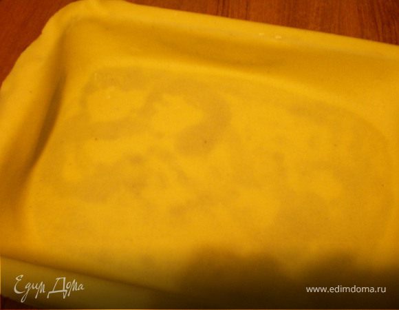 Форму смазать маслом..Раскатать большой шарик теста до 0,3см. толщиной .Уложить в форму. Края раскатного листа должна свисать с краев формы на 9см. Слегка прижать.
