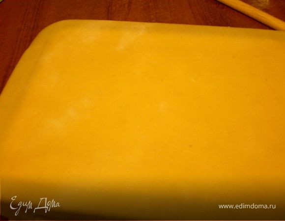 Последний большой шарик раскатать,уложить на начинку .Как и первый лист должна свисать с краев формы.
