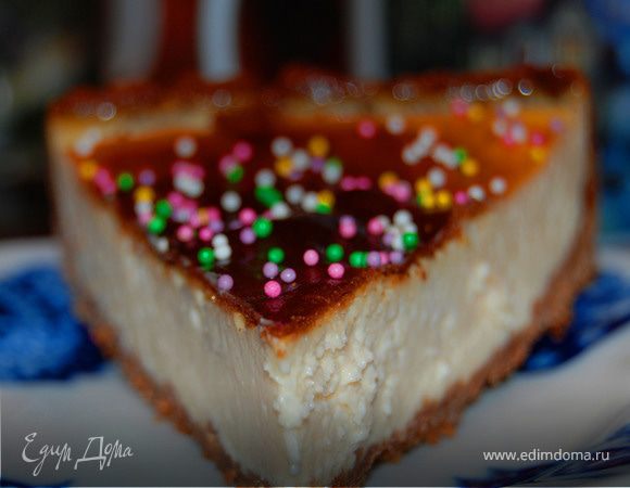 Оборачиваем форму двойным слоем фольги, чтобы в нее не затекла жидкость, ставим в другую форму большего диаметра и наливаем в последнюю столько воды, чтобы она доходила со середины бортиков формы с чизкейком. Отправляем в разогретую до 160 градусов духовку на час и 20 минут.

По истечении этого времени выключаем духовку, приоткрываем дверцу и оставляем так еще на час. После этого вынимаем чизкейк и ставим в холодильник минимум на 4 сама, а лучше на ночь.

Перед подачей проводим ножом вдоль стенок формы, снимаем бортик и перекладываем чизкейк на блюдо. Украшаем по желанию.